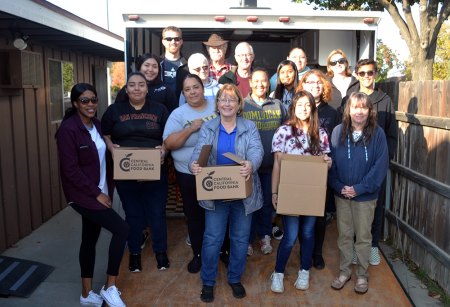 Lemoore Christian Aid volunteers take a break for a group photo before they get back to packing boxes with food for the holiday season.